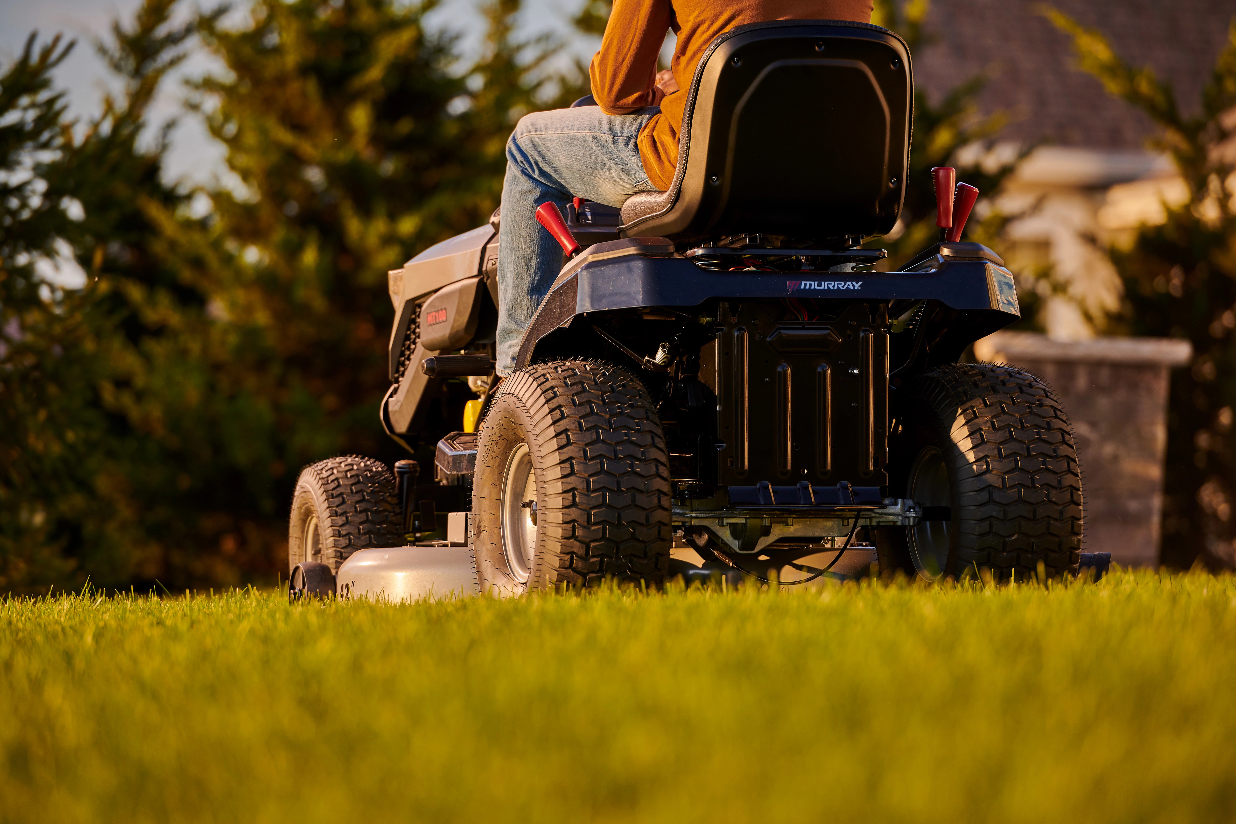 Man comfortably starting and driving a Murray riding lawn mower powered by a Briggs & Stratton PXi V-Twin engine